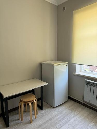 a small kitchen with a table and a refrigerator at Apart Hotel in Shymkent