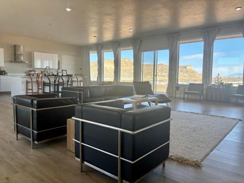 a living room with couches and a kitchen at Canyon Dweller Luxury home with Mesa views in Big Water