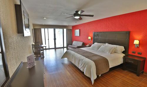 una camera con un grande letto e una parete rossa di Hotel Victoria Inn a San Juan del Río