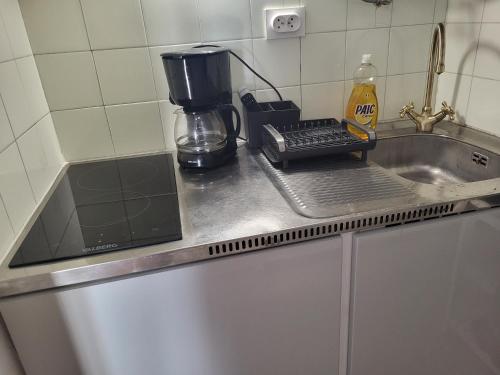 - un comptoir de cuisine avec une cafetière à côté d'un évier dans l'établissement Le Kiowas CARNON PLAGE, à Carnon-Plage