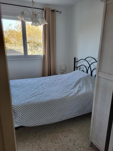 - une chambre avec un lit à côté d'une fenêtre dans l'établissement Le Kiowas CARNON PLAGE, à Carnon-Plage