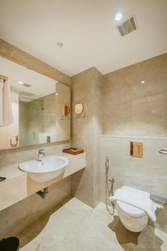 a bathroom with a toilet and a sink at Loft Business Hotel in Kakkanad