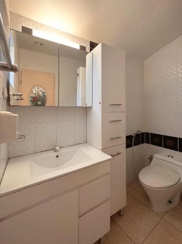 a white bathroom with a sink and a toilet at Sunset Beach Resort in Moalboal