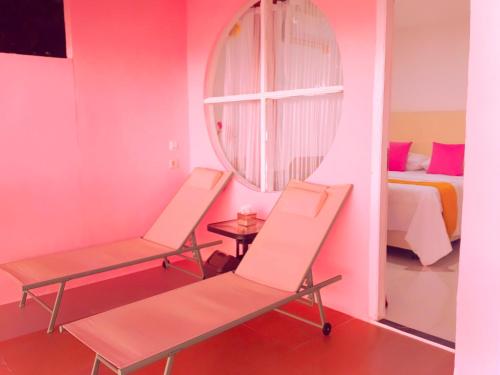 a room with two chairs and a bed and a mirror at Noel Cottage in Ngurblut