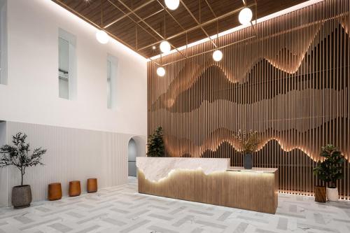 a lobby with a reception desk and a wall with feathers at Somerset Sukhumvit 71 Bangkok in Bangkok