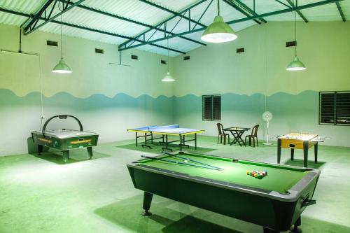 a room with a pool table and ping pong tables at RG Hotels and Resort in Mālūr