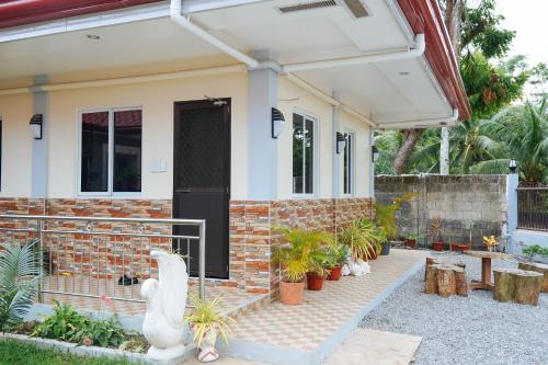 a house with a black door and some plants at AJ Residences Apartelle Camotes RedPartner in Esperanza