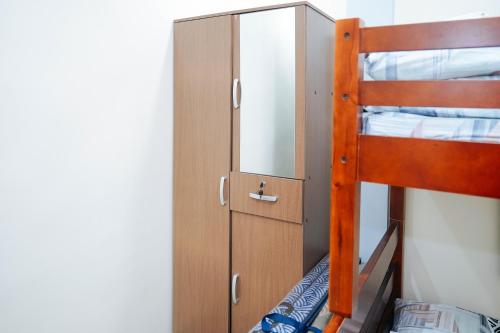 a bunk bed with a mirror and a cabinet at AJ Residences Apartelle Camotes RedPartner in Esperanza