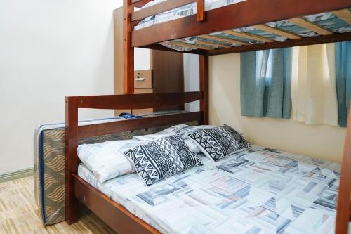 a bunk bed in a room with two bunk beds at AJ Residences Apartelle Camotes RedPartner in Esperanza