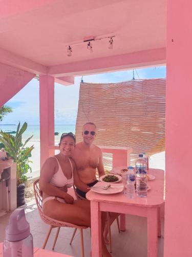 a man and a woman sitting at a table at Noel Cottage in Ngurblut