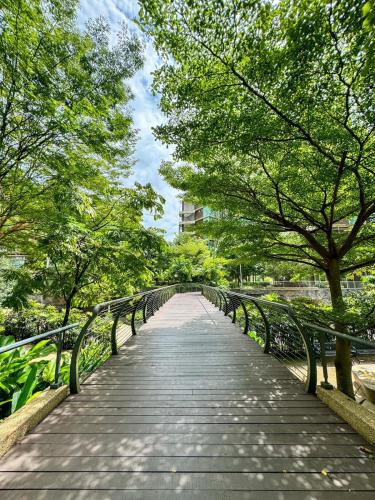 a wooden bridge in a park with trees at KidsVille Slide PlayNest at Afiniti, Walking to Legoland JB, Johor, Malaysia in Iskandar Puteri