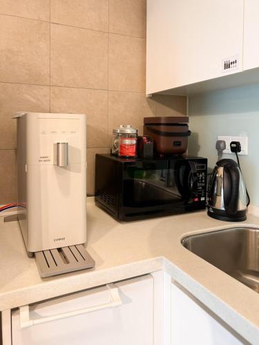 a kitchen counter with a microwave and a refrigerator at KidsVille Slide PlayNest at Afiniti, Walking to Legoland JB, Johor, Malaysia in Iskandar Puteri