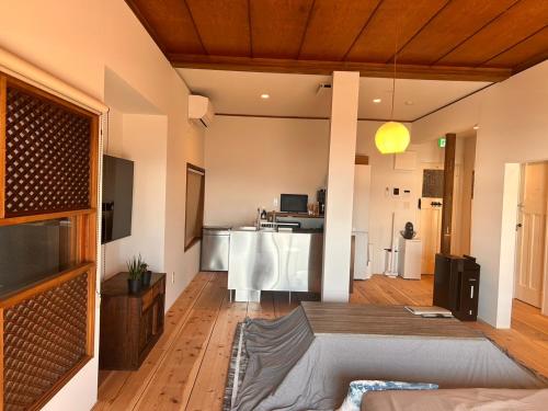 a living room with a couch and a kitchen at 真鶴海の見える古民家風ジャパニーズルームapartment Hotel途乃中W2 in Manazuru