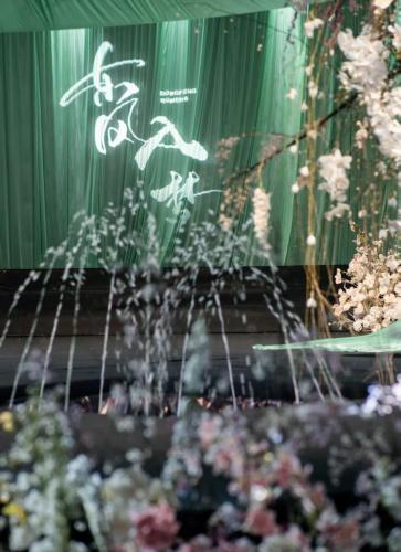 a stage with flowers in front of a green curtain at Shangri-La Wuhan,Close to The Mixc with three subway lines in Wuhan