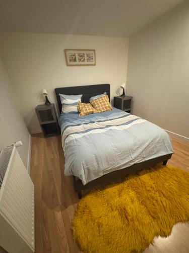 - une chambre avec un lit et un tapis jaune dans l'établissement Dépendance COLOMBES, à Saint-Germain-en-Laye