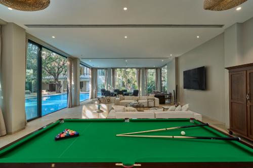 a pool table in a living room with a pool table at SaffronStays Hermes Cove in Kīhīm