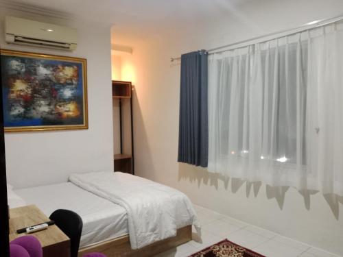 a small bedroom with a bed and a window at Hotel Rimadi in Jakarta