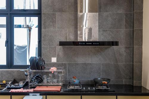 a kitchen with a counter with a stove top oven at Dreamspace Villa I Afamosa Melaka in Kampong Pulau Sebang