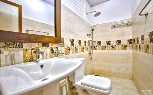 a bathroom with a sink and a toilet at Sethuki Elephant Cottage in Kaduwela