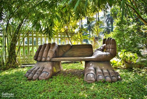 a statue of a cat laying on a bench at Sethuki Elephant Cottage in Kaduwela