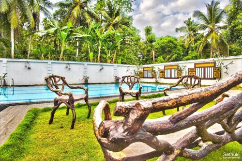 a metal bench in front of a pool at Sethuki Elephant Cottage in Kaduwela