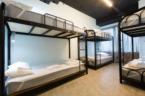 Una habitación con tres literas. en Pathways Hostel, en Kaohsiung