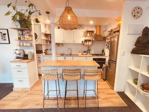 a kitchen with a island with bar stools at The Lazy Surfer in New Plymouth