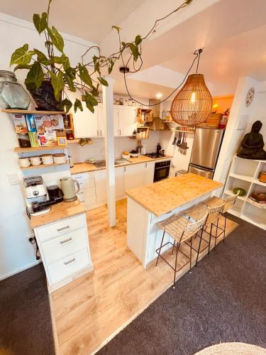 a kitchen with white cabinets and a wooden table at The Lazy Surfer in New Plymouth