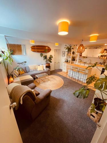 a living room with a couch and a kitchen at The Lazy Surfer in New Plymouth