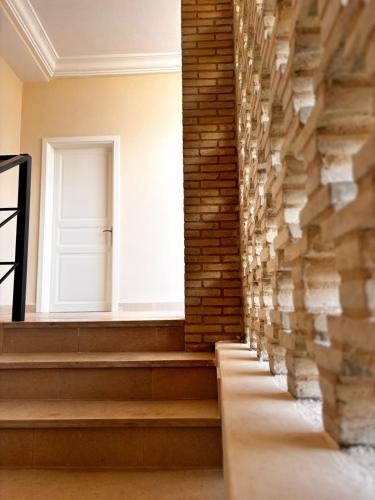 a hallway with a window and a brick wall at Résidence Tozeur Almadina chambres Supérieures in Tozeur