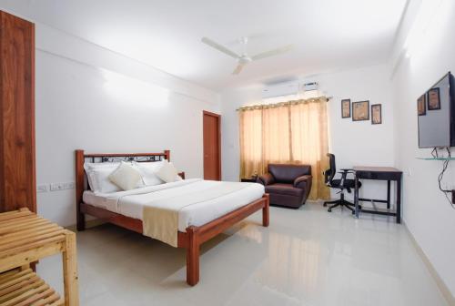 een slaapkamer met een bed, een bureau en een stoel bij Achates Corporate Services in Bangalore