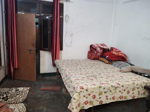 a bedroom with a bed with a comforter on it at Chauhans house in Prayagraj