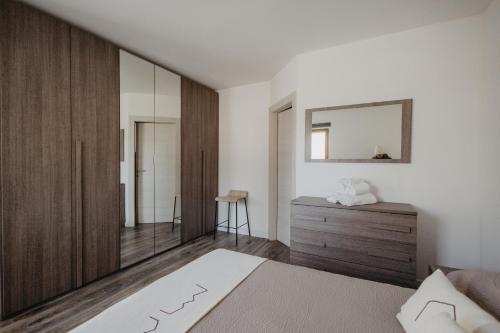 a bedroom with a bed and a dresser and a mirror at Borgo Antico Mountain Lodge in Sappada