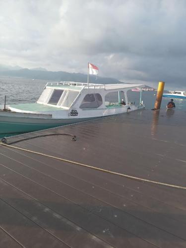 a boat sitting on top of a pier at BTN Mahkota Pemenang 13 Tamarin 3A in Pawenang