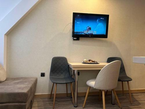 a room with a table and a tv on the wall at Sweet Home Konaci in Kopaonik