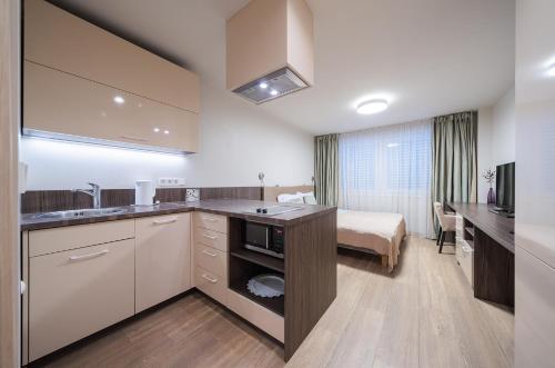 a hotel room with a kitchen and a bed at Gynėjų Self Check-in Apartments - Lollo Stay in Vilnius