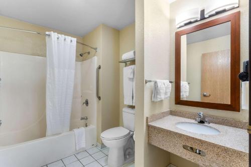 a bathroom with a toilet and a sink and a mirror at Comfort Inn & Suites Greeley in Greeley