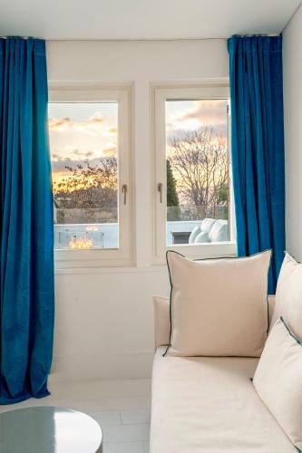 a living room with blue curtains and a couch at Plaka Villa with Epic Acropolis Views in Athens