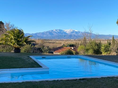 - une piscine dans une cour avec des montagnes en arrière-plan dans l'établissement Villa d'exception à louer pour vos vacances, à Pollestres