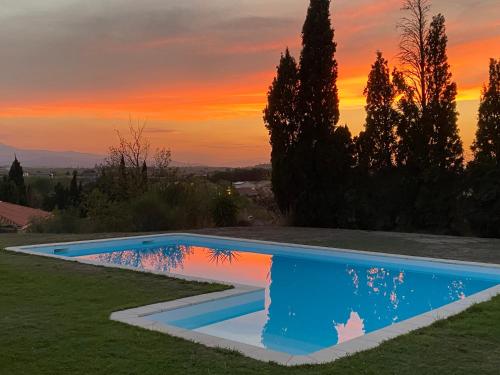 une piscine avec un coucher de soleil en arrière-plan dans l'établissement Villa d'exception à louer pour vos vacances, à Pollestres