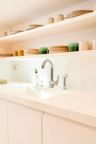 a white kitchen with a sink and shelves at Plaka Villa with Epic Acropolis Views in Athens
