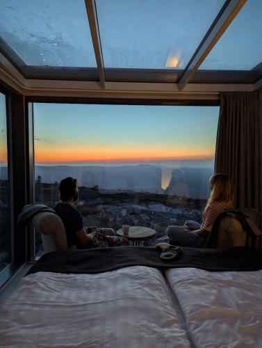 a group of people sitting in a room with a large window at Pyhä Dreams in Pyhätunturi