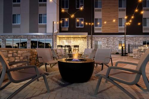 a patio with chairs and a fire pit in front of a building at Everhome Suites Nampa Boise in Nampa
