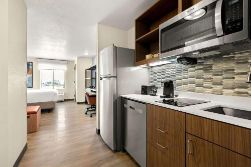 a kitchen with a refrigerator and a sink and a microwave at Everhome Suites Nampa Boise in Nampa