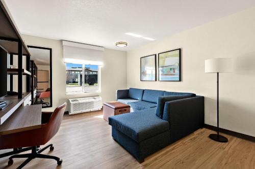 a living room with a blue couch and a desk at Everhome Suites Nampa Boise in Nampa