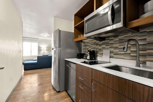 a kitchen with a sink and a stainless steel refrigerator at Everhome Suites Nampa Boise in Nampa