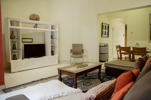 a living room with a couch and a tv at Furnished apartment Munyonyo-Kampala in Kampala