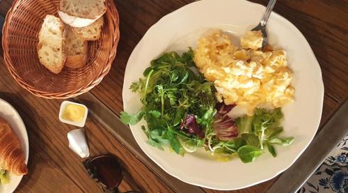 a plate of food with salad and bread on a table at SLEEPWELL NOWY ŚWIAT - entrance from Ordynacka 14St, through the courtyard in Warsaw