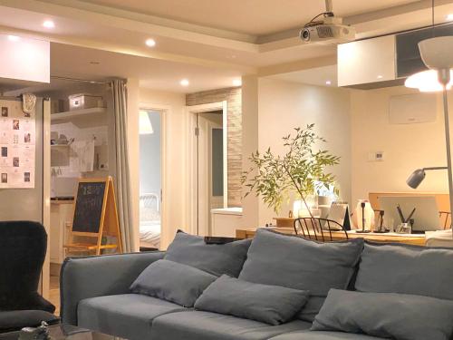 a living room with a blue couch and a kitchen at Shanghai Hills & Moment Family house close to The Bund in Shanghai