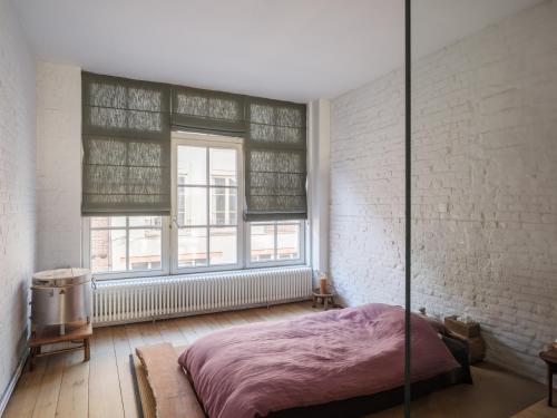 Un dormitorio con una cama y una pared de ladrillo. en Brooklyn Five, en Gante